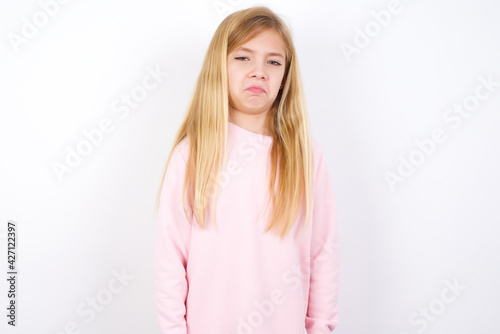 beautiful caucasian little girl wearing pink hoodie over white background with snobbish expression curving lips and raising eyebrows  looking with doubtful and skeptical expression  suspect and doubt.