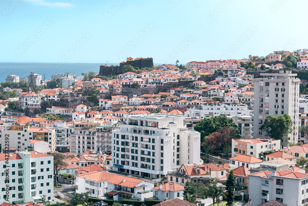 funchal downtown madeira island with fortress on background,  rooftop houses and buildings
