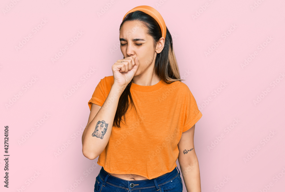 Young hispanic woman wearing casual clothes feeling unwell and coughing as symptom for cold or bronchitis. health care concept. Young hispanic woman wearing casual clothes feeling unwell and coughing as symptom for cold or bronchitis. health care concept.