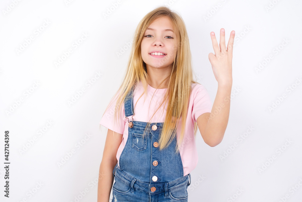 beautiful caucasian little girl wearing jeans overall over white background smiling and looking friendly, showing number three or third with hand forward, counting down beautiful caucasian little girl wearing jeans overall over white background smiling and looking friendly, showing number three or third with hand forward, counting down