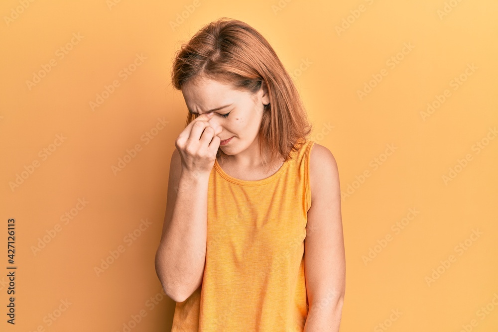 Young caucasian woman wearing casual style with sleeveless shirt tired rubbing nose and eyes feeling fatigue and headache. stress and frustration concept. Young caucasian woman wearing casual style with sleeveless shirt tired rubbing nose and eyes feeling fatigue and headache. stress and frustration concept.