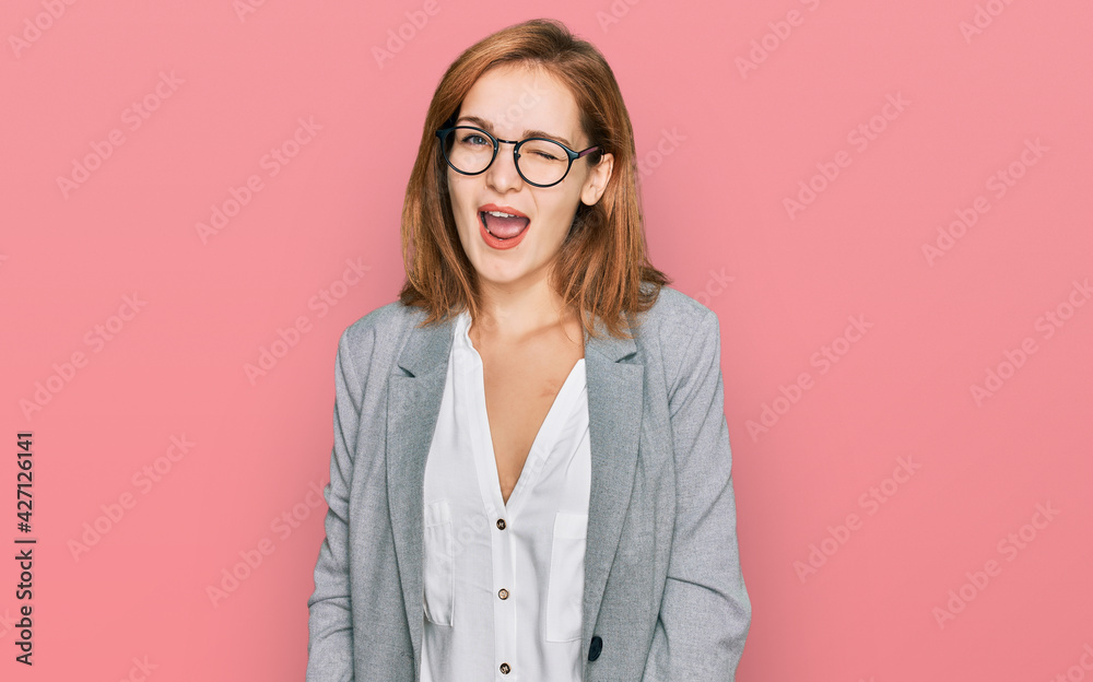 Young caucasian woman wearing business style and glasses winking looking at the camera with sexy expression, cheerful and happy face.