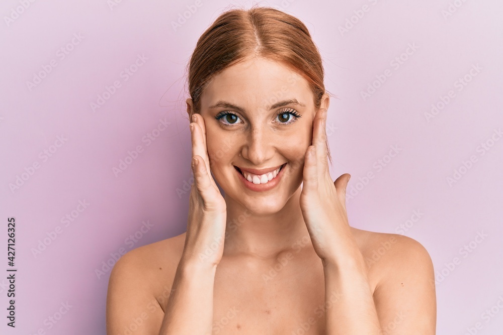 Young irish woman standing topless stretching skin face with hands smiling with a happy and cool smile on face. showing teeth. Young irish woman standing topless stretching skin face with hands smiling with a happy and cool smile on face. showing teeth.