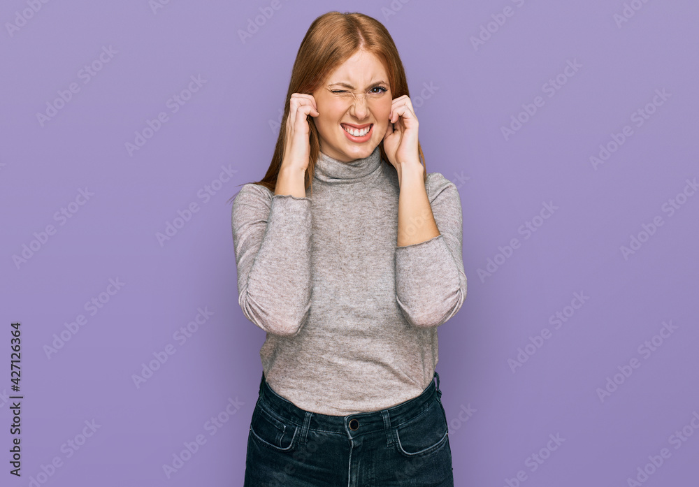 Young irish woman wearing casual clothes covering ears with fingers with annoyed expression for the noise of loud music. deaf concept. Young irish woman wearing casual clothes covering ears with fingers with annoyed expression for the noise of loud music. deaf concept.