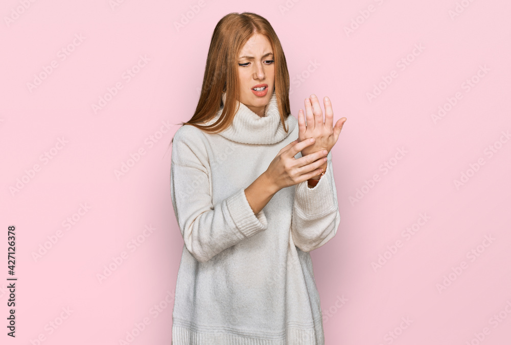 Young irish woman wearing casual winter sweater suffering pain on hands and fingers, arthritis inflammation Young irish woman wearing casual winter sweater suffering pain on hands and fingers, arthritis inflammation