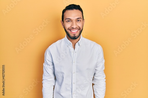 Hispanic man with beard wearing business shirt with a happy and cool smile on face. lucky person.