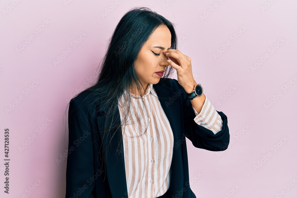 Young hispanic girl wearing business clothes tired rubbing nose and eyes feeling fatigue and headache. stress and frustration concept. Young hispanic girl wearing business clothes tired rubbing nose and eyes feeling fatigue and headache. stress and frustration concept.