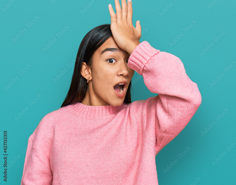 Young asian woman wearing casual winter sweater surprised with hand on head for mistake, remember error. forgot, bad memory concept. Young asian woman wearing casual winter sweater surprised with hand on head for mistake, remember error. forgot, bad memory concept.