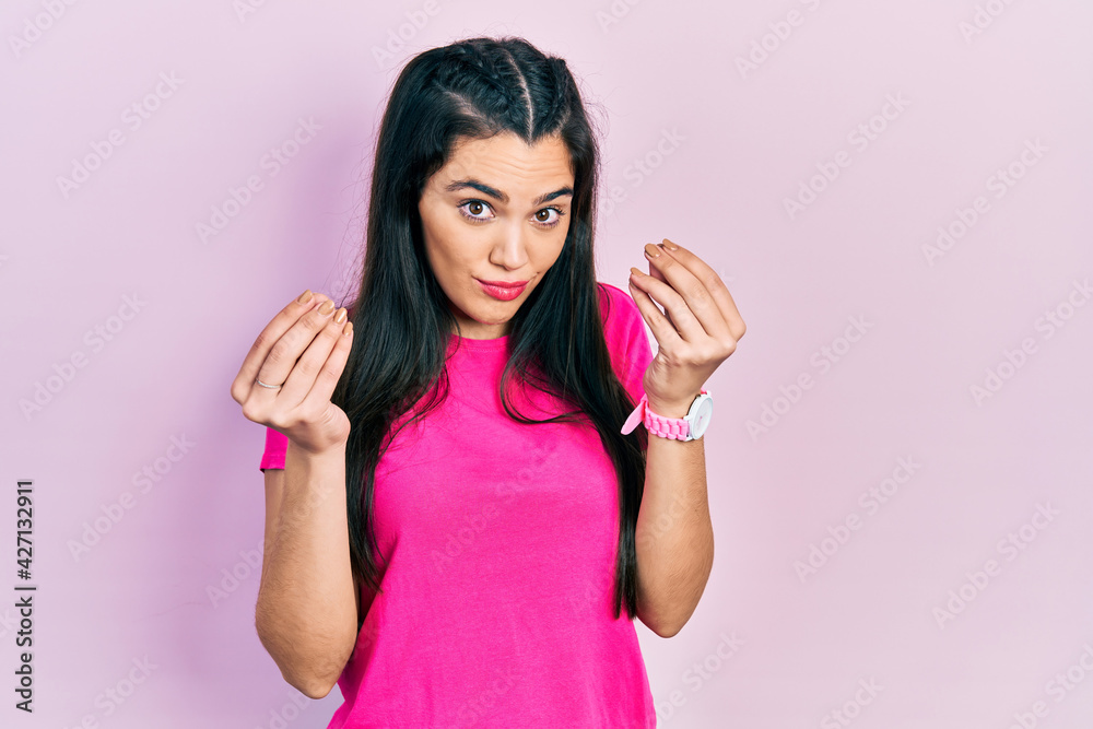 Young hispanic girl wearing casual pink t shirt doing money gesture with hands, asking for salary payment, millionaire business Young hispanic girl wearing casual pink t shirt doing money gesture with hands, asking for salary payment, millionaire business