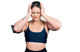 Young hispanic woman wearing sportswear suffering from headache desperate and stressed because pain and migraine. hands on head.