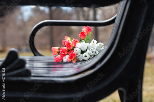 Bouquet of flowers left on park bench as a memorial. 