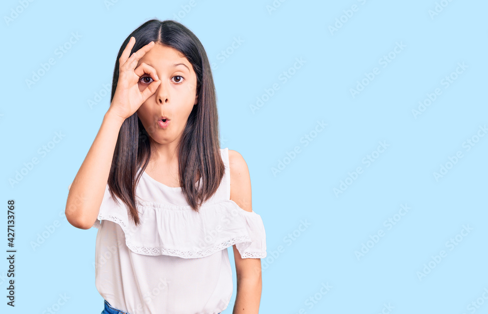 Beautiful child girl wearing casual clothes doing ok gesture shocked with surprised face, eye looking through fingers. unbelieving expression. Beautiful child girl wearing casual clothes doing ok gesture shocked with surprised face, eye looking through fingers. unbelieving expression.
