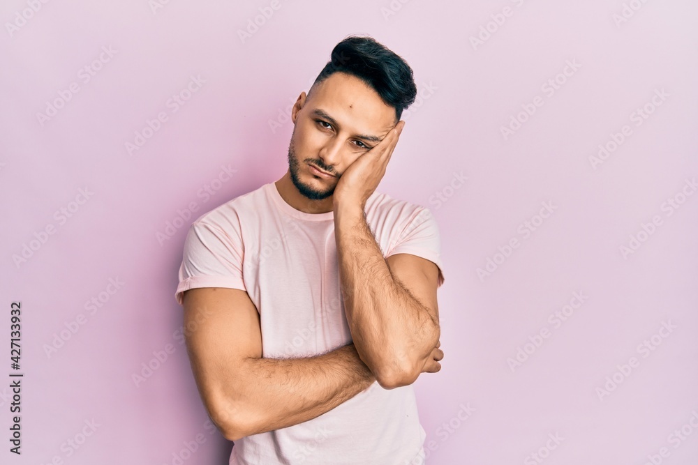 Young arab man wearing casual clothes thinking looking tired and bored with depression problems with crossed arms. Young arab man wearing casual clothes thinking looking tired and bored with depression problems with crossed arms.