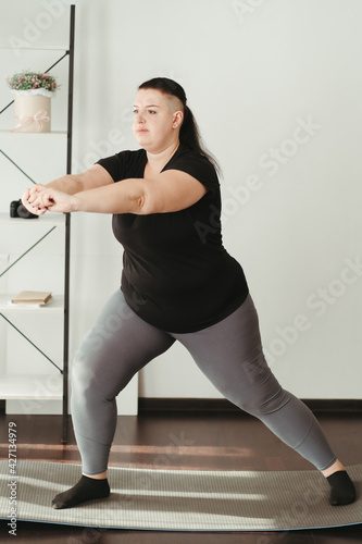 Fototapeta Naklejka Na Ścianę i Meble -  Overweight woman doing physical exercises at home