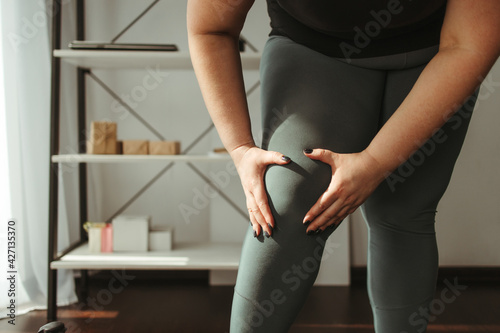 overweight woman suffering from the knee ache