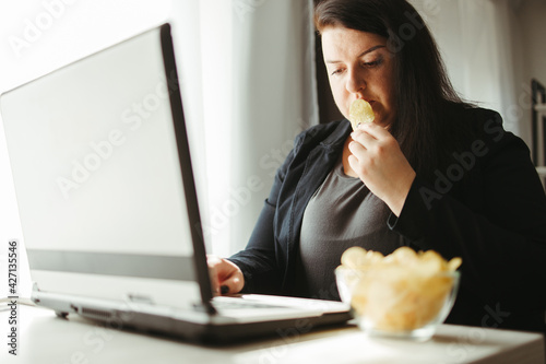 Woman eating junk food, snacking with chips