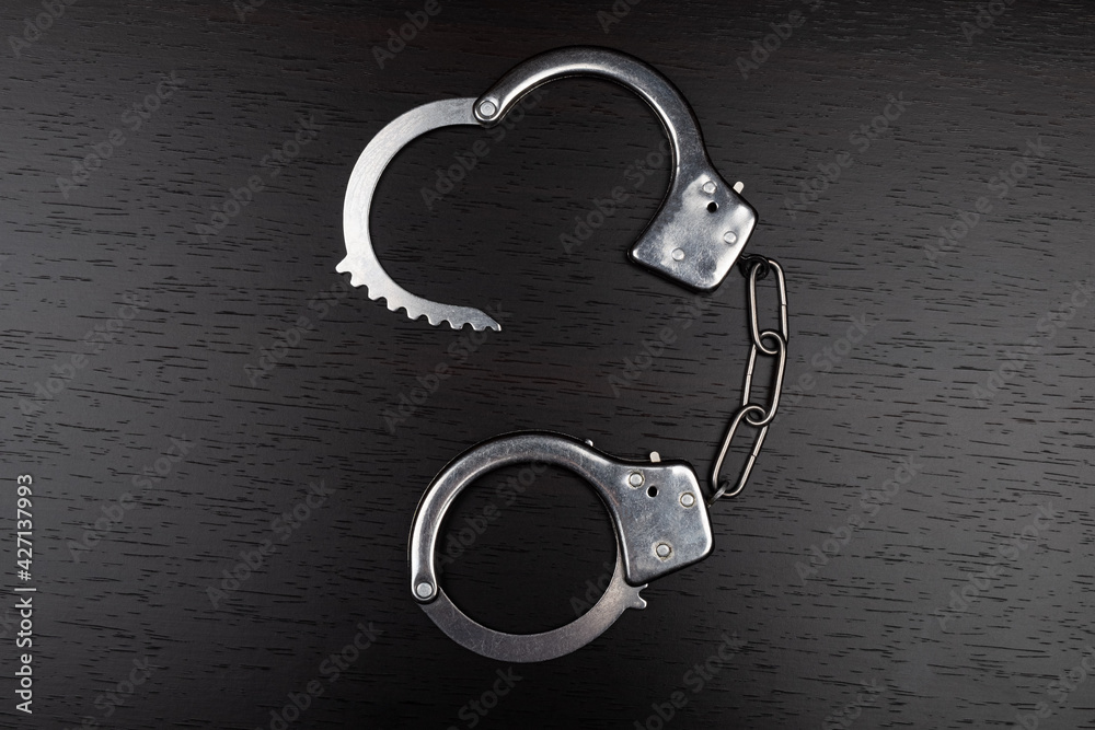 handcuffs on table, concept of arrest for violation. handcuffs on table, concept of arrest for violation.