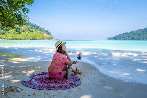 Woman sitting on the beach enjoying summertime.