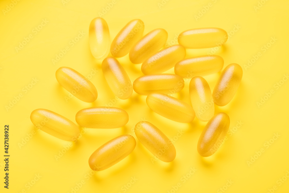 Omega 3 capsules on yellow background. Fish oil softgels. Supplement food vitamin D capsules. Top view - Image Omega 3 capsules on yellow background. Fish oil softgels. Supplement food vitamin D capsules. Top view - Image