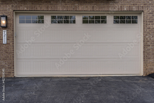 Beige double car garage door with brick facade on a new town house