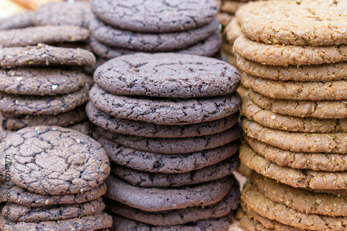 Light and dark flat biscuits with ground nut additives. Round cookie are stacked in piles. photo