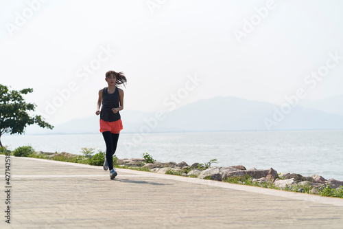 Photography young asian woman jogging outdoors by the sea