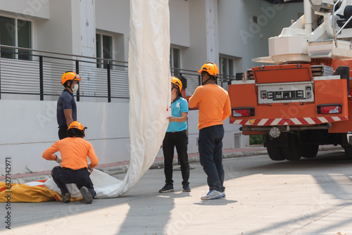 Foto Firemen preparing a yellow bag containing a fire escape device that use as verti