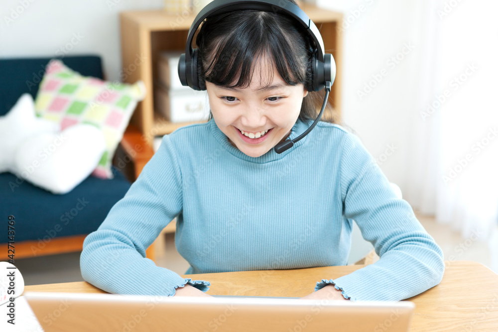 インカムをつけてパソコンを操作する女の子