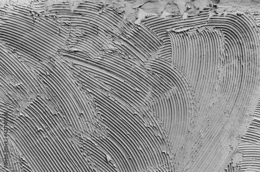 Gray wall glue plaster comb surface prepared for tiling.Tile adhesive notched trowel patterns. Adhesive background. Cement wall Gray wall glue plaster comb surface prepared for tiling.Tile adhesive notched trowel patterns. Adhesive background. Cement wall