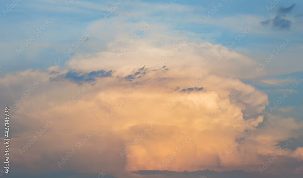 Stormy sky with dramatic clouds from an approaching thunderstorm at sunset.Big red Storm Cloud in sunset light. Rain Cloud.space for add text