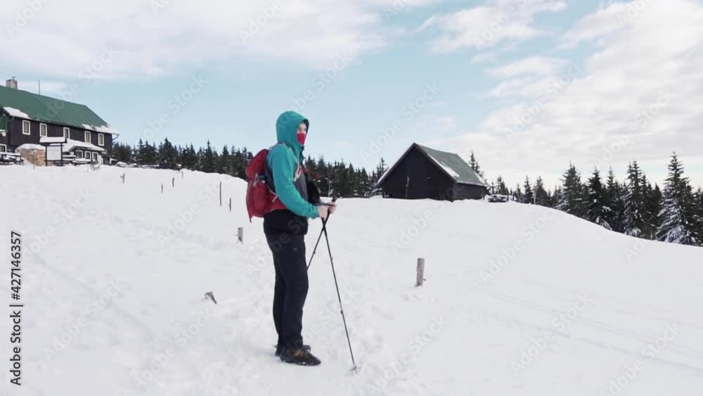 Mountaineer enjoying beautiful view from top of mountain with lodge in background. Dolly forward. Mountaineer enjoying beautiful view from top of mountain with lodge in background. Dolly forward.