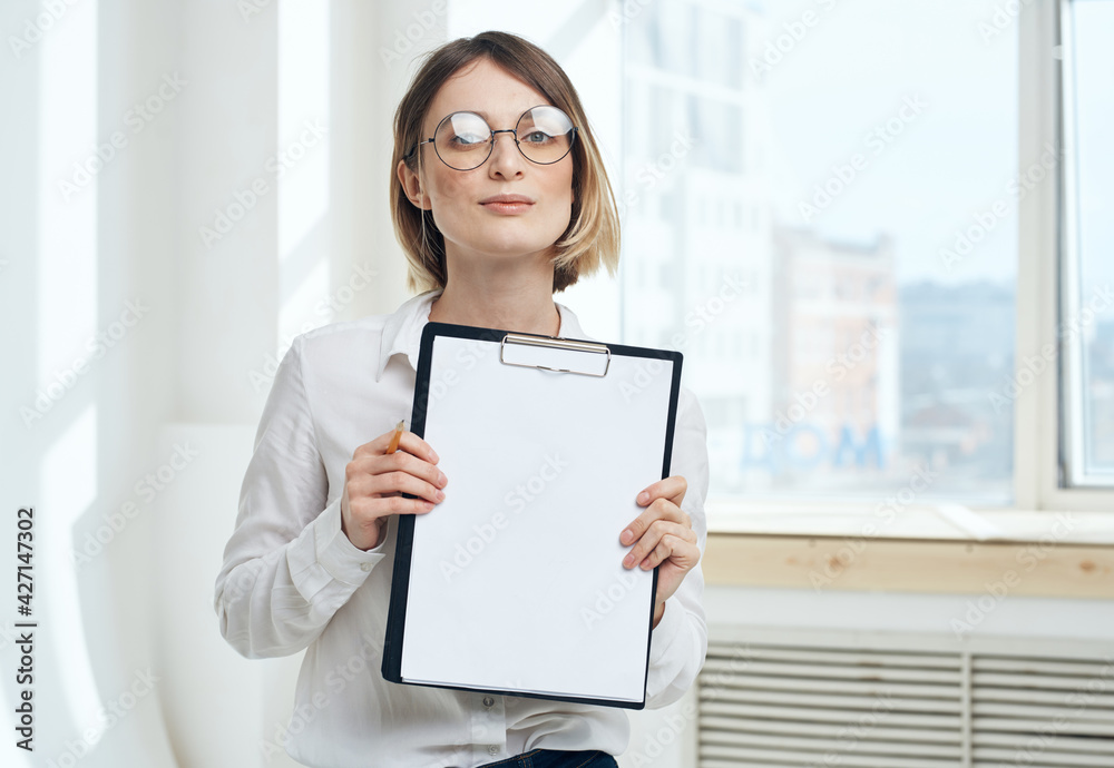Cropped view of woman with folder of documents near window indoors Cropped view of woman with folder of documents near window indoors