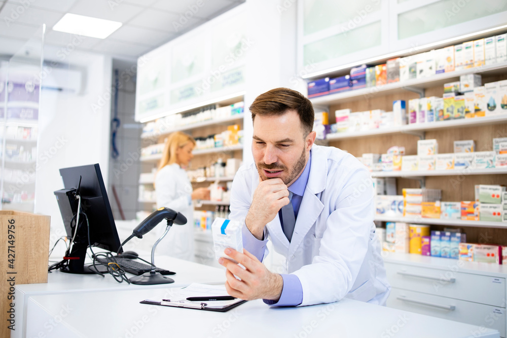 Pharmacist working in pharmacy store and selling medicines.