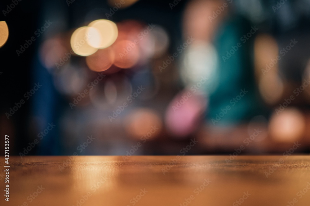 Wood table top on of abstract blurred restaurant lights background