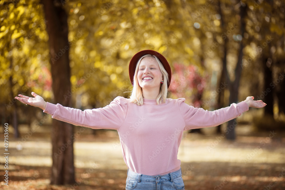Young smiling blond woman enjoying in the park. Young smiling blond woman enjoying in the park.