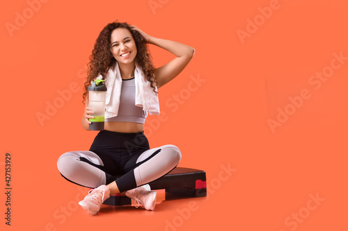 Fototapeta Naklejka Na Ścianę i Meble -  Beautiful young woman with bottle of water and stepper on color background