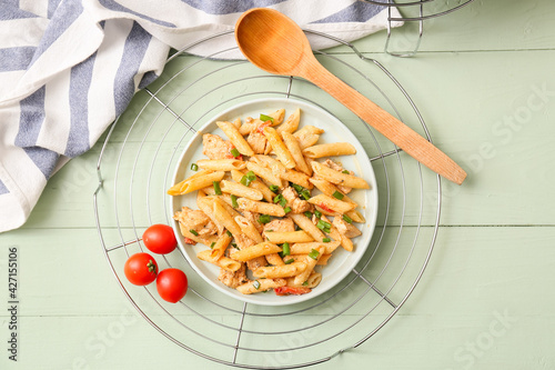 Plate with cajun chicken pasta on color wooden background