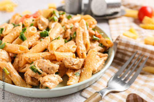 Plate with cajun chicken pasta on table, closeup