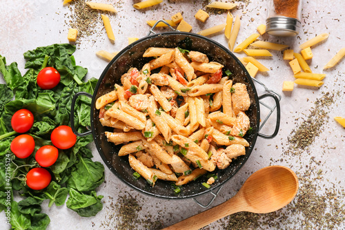 Frying pan with tasty cajun chicken pasta on table