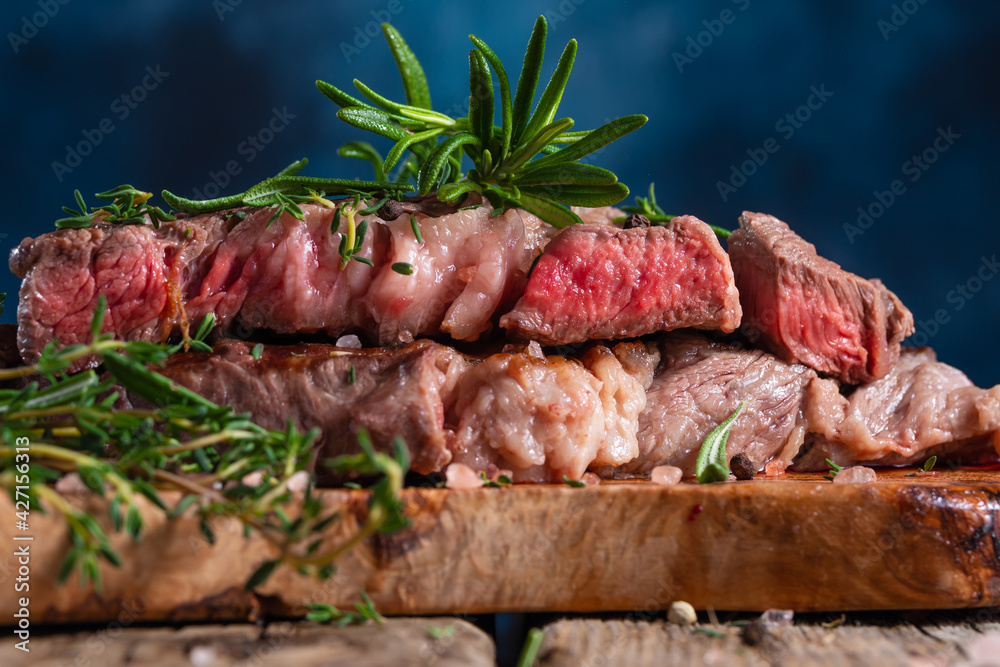 Medium cooked steak with rosemary close-up. Meat recipes and illustrations for meat recipes, recipe book Medium cooked steak with rosemary close-up. Meat recipes and illustrations for meat recipes, recipe book