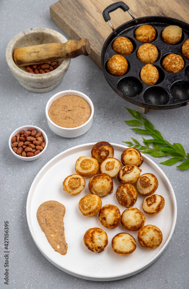 Suji appe or appam served on a appam pan with peanuts and tamarind chutney Suji appe or appam served on a appam pan with peanuts and tamarind chutney