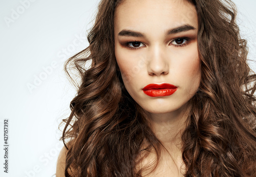 Portrait of a beautiful woman with red lips and curly hair at the barbershop