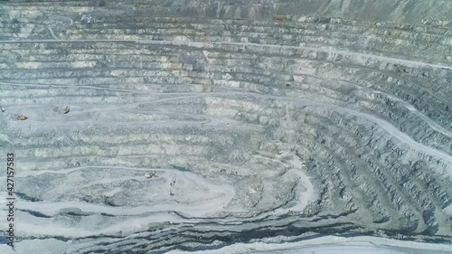 Aerial view of Huge asbestos quarry.  Inside the quarry there is a excavators and serpentine road for trucks. In the center of the shot is a site loaded with explosives.
