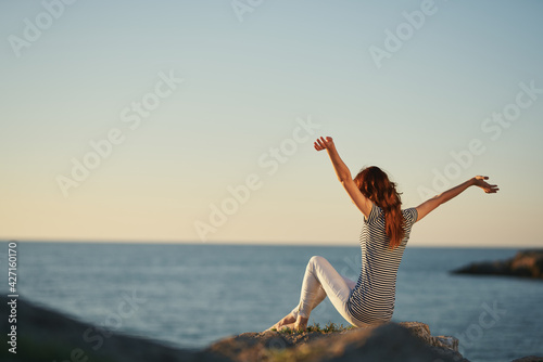 a traveler in the mountains by the sea gestures with her hands
