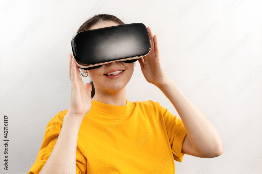 Virtual Reality concept. Portrait of a young smiling woman in virtual reality glasses. White background Virtual Reality concept. Portrait of a young smiling woman in virtual reality glasses. White background