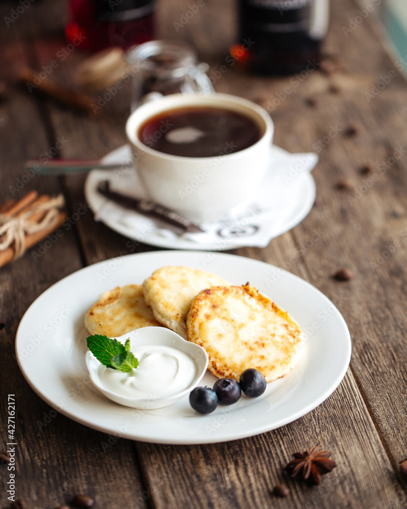 Russian breakfast cottage cheese pancakes with sour cream and coffee