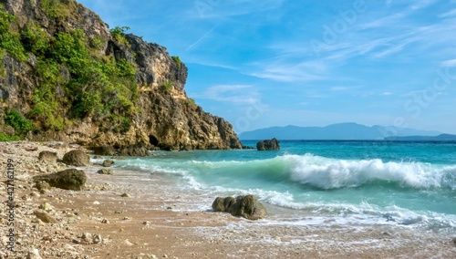 Motion blurred waves breaking on a secluded rocky beach in the tropical resort area of Puerto Galera on Mindoro Island in the Philippines.