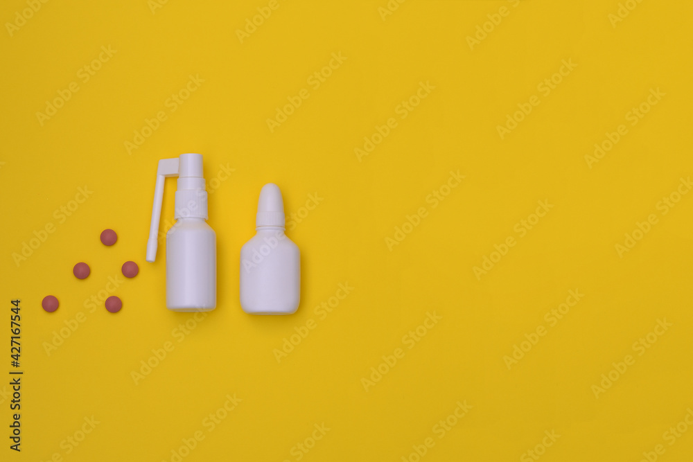 Spray for the nose and for the throat, a pill to treat colds and grippe. flu treatments. Copy space for text. mockup, Top view. flat lay. on a yellow background Spray for the nose and for the throat, a pill to treat colds and grippe. flu treatments. Copy space for text. mockup, Top view. flat lay. on a yellow background