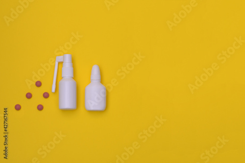 Spray for the nose and for the throat, a pill to treat colds and grippe. flu treatments. Copy space for text. mockup, Top view. flat lay. on a yellow background