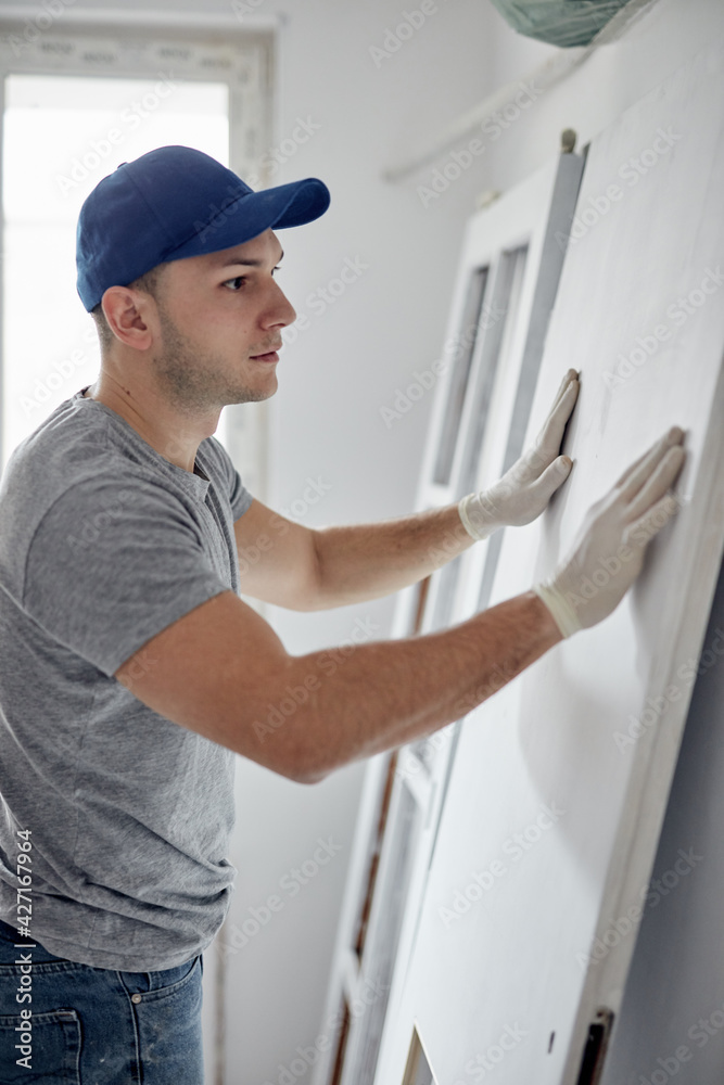 Young adult man working on a DIY budget renovation of his new home apartment. Young adult man working on a DIY budget renovation of his new home apartment.